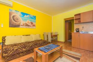 a yellow living room with a couch and a table at Villa Nena Apartments Sutomore in Sutomore