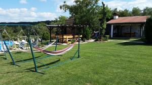 un patio con parque infantil y 2 hamacas en Guest House Relax, en Dŭbravka