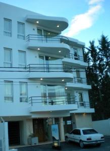 プエルト・マドリンにあるKosten al Marの建物の前に駐車された白い車