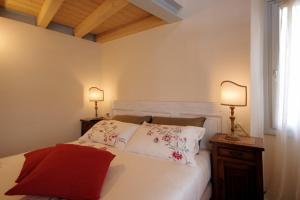 a bedroom with a bed with two lamps on tables at Guest House Al Castello in Gravedona