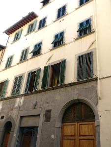 - un grand bâtiment blanc avec une porte en bois dans l'établissement Mamo Florence - GM Apartment, à Florence