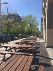 a row of wooden picnic tables on a city street at Pension Payvi in Pamplona