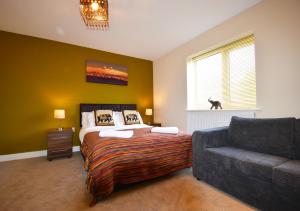 a bedroom with a bed and a couch at Gorse House in Leicester