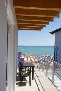 a balcony with a table and a view of the beach at Residence la Perla in Caorle