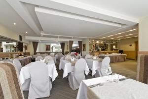 a dining room with white tables and chairs at AirInn Vilnius Hotel in Vilnius