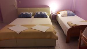 a bedroom with two beds with pillows on them at Guesthouse Ivan in Skradin