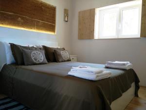 a bedroom with a bed with towels on it at Taipa 2 - Casas de Campo do Junqueirinho in Bicos