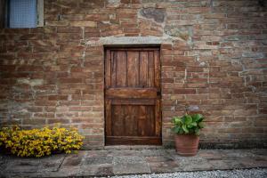 een houten deur op een stenen muur met bloemen bij Borgo Amarrante in Montaione