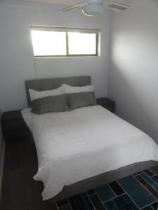 a bedroom with a white bed with a window at Prime location & spacious in Adelaide