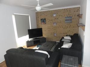 a living room with two black couches and a flat screen tv at Prime location & spacious in Adelaide
