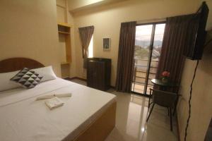 Schlafzimmer mit einem Bett und einem Fenster mit Aussicht in der Unterkunft Heart Hotel and Services in Dumaguete
