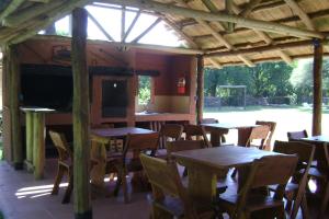 a restaurant with wooden tables and chairs and a large window at Cabañas La Curucucha in Nono