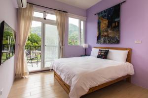a purple bedroom with a bed and a balcony at ITSF B&B in Guanshan