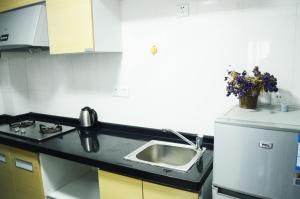 a kitchen with a sink and a counter top at Xizhengjia Apartment Hotel Pazhou Complex in Guangzhou