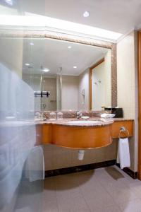 bagno con grande specchio e lavandino di Harbour Plaza North Point a Hong Kong
