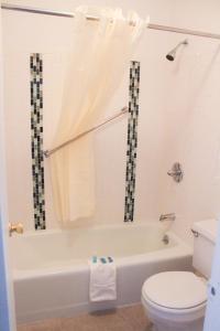 a bathroom with a white tub and a toilet at Chaparral Motor Inn in Burlington