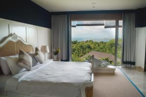a bedroom with a large bed and a large window at Luxury Apartment at AYANA Residences in Jimbaran +132 photos