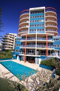 a large building with a swimming pool in front of it at Sunrise Luxury Apartments in Tuncurry