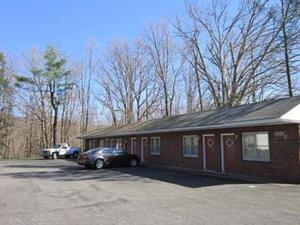 um edifício com um carro estacionado num parque de estacionamento em Cadet Motel em Cornwall-on-Hudson