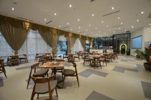 a restaurant with tables and chairs in a building at Signature International Hotel China Town in Kuala Lumpur