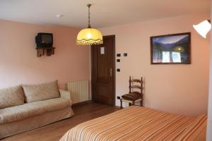 a living room with a couch and a tv at Hotel Bellevue in Gignod