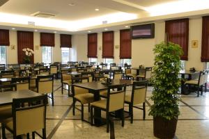 a dining room with tables and chairs and a tv at Hotel Route-Inn Mojiko in Kitakyushu