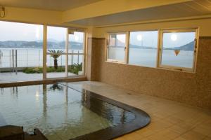 a swimming pool in a house with a view of the water at Hotel Route-Inn Mojiko in Kitakyushu