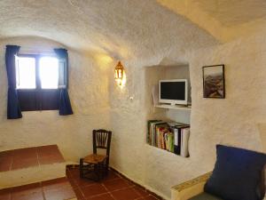 een woonkamer met een raam en een tv aan de muur bij Casa Cueva Guadix in Guadix