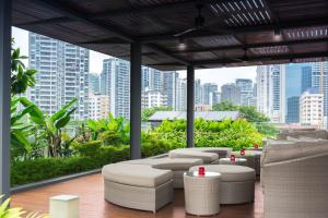 a rooftop patio with tables and chairs and a city skyline at ST Residences Novena in Singapore