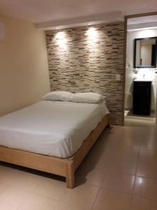 a bedroom with a bed and a brick wall at Hotel Los Angeles in Tequesquitengo