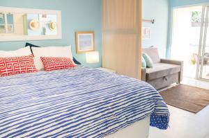 a bedroom with a bed and a chair and a window at Apartamento Solar Água 107 in Pipa +14 photos