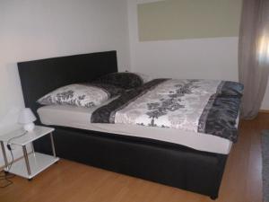 a bed with a black headboard and pillows on it at Fa Haack in Neuried