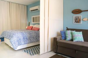 una camera con letto e divano di Apartamento Solar Água 107 a Pipa