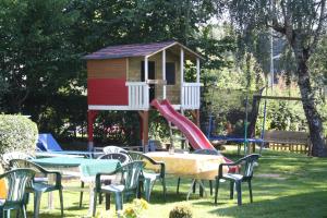 a playground with a slide and chairs and a play house at Landgasthaus Alter Posthof in Halsenbach