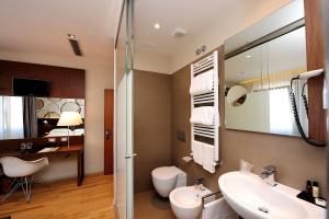 uma casa de banho com um lavatório, um WC e um espelho. em Dal Moro Gallery Hotel em Assis