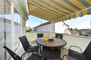 eine Terrasse mit Tisch und Stühlen auf einem Balkon in der Unterkunft Apartman Kresan in Sukošan