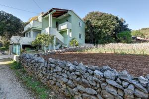 ein Haus mit einer Steinmauer und einem Gebäude in der Unterkunft Apartman Kresan in Sukošan