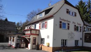 un edificio blanco con un cartel en el costado en Landgasthaus Alter Posthof, en Halsenbach