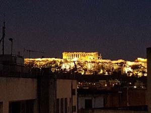 een uitzicht op de acropolis verlicht in de nacht bij ADMETUS PSYRRI LOFT by K&K in Athene