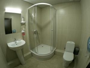 a bathroom with a shower and a toilet and a sink at Hotel Imperial in Tbilisi City