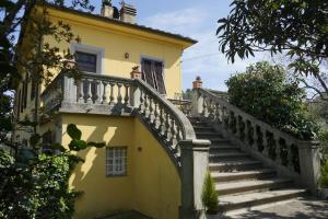 una casa amarilla con una escalera delante de ella en Casolare Al Dopolavoro, en Lucca