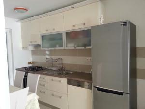 a kitchen with a stainless steel refrigerator at Kartini Apartment in Nin