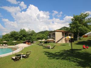 um resort com piscina e cadeiras e um edifício em Belvilla by OYO Il Grano em Apecchio