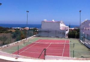 una pista de tenis con el océano en el fondo en Duplex Turisticos MojaMar Playa, en Mojácar