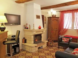 ein Wohnzimmer mit einem Kamin und einem TV in der Unterkunft Attractive holiday home with swimming pool in Montagnac