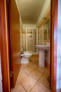 uma casa de banho com um lavatório, um WC e um lavatório. em Agriturismo Casa Guidoni em Follonica