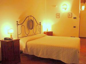 ein Schlafzimmer mit einem weißen Bett und zwei Lampen in der Unterkunft Belvilla by OYO Montecorneo Monolocale in Perugia