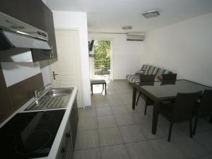 サン・ニコラオにあるComfy Apartment in Cervione with Swimming Poolのキッチン、リビングルーム(ソファ、テーブル付)