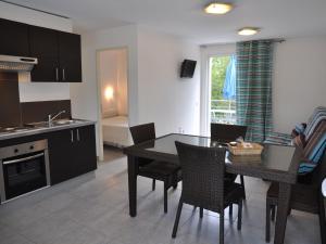 サン・ニコラオにあるComfy Apartment in Cervione with Swimming Poolのキッチン、ダイニングルーム(テーブル、椅子付)