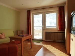 un soggiorno con divano, tavolo e finestra di Haus Arnika a Nauders